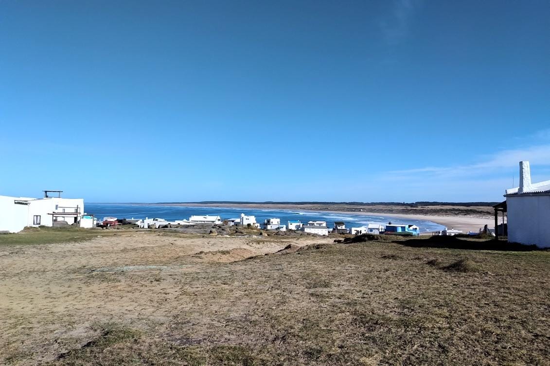 A landscape with a beach and buildings

Description automatically generated