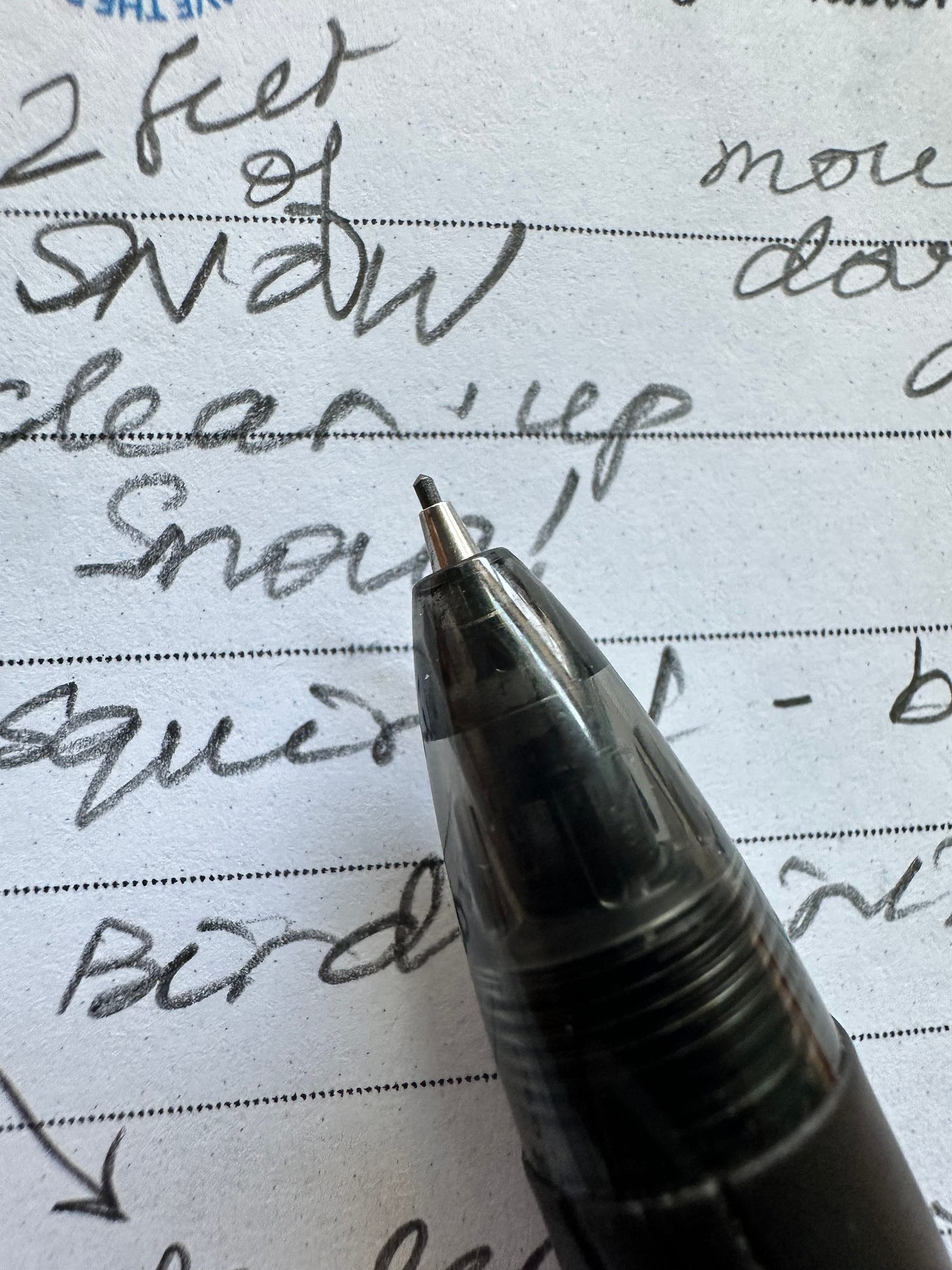 a mechanical pencil tip and scribbled writing on a notebook page