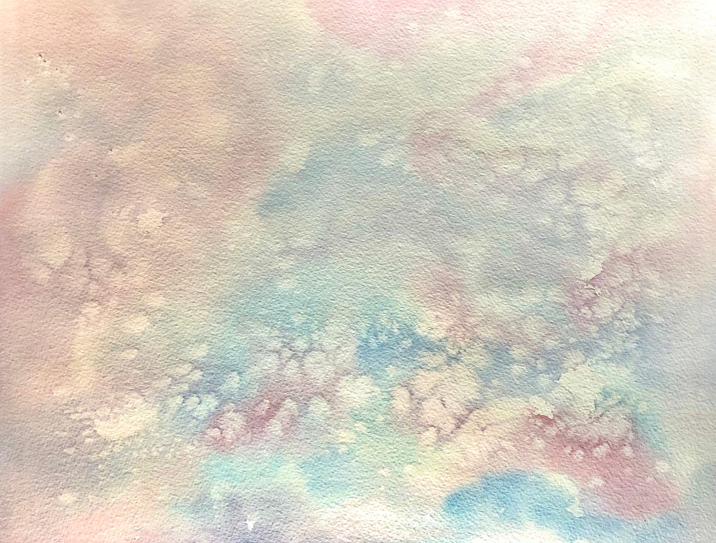 A soft watercolour wash in pastel tones of pink and blue blending together on textured paper, creating an abstract dreamy background with organic flowing shapes and gentle colour transitions.