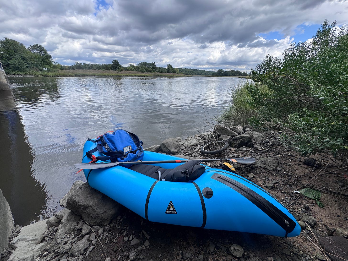 Blue packraft and paddle at water's edge