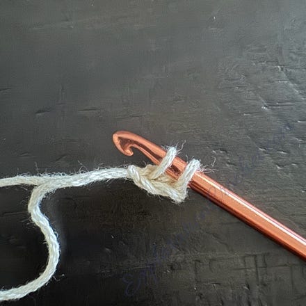 A crochet hook with a crochet hook and a string

Description automatically generated