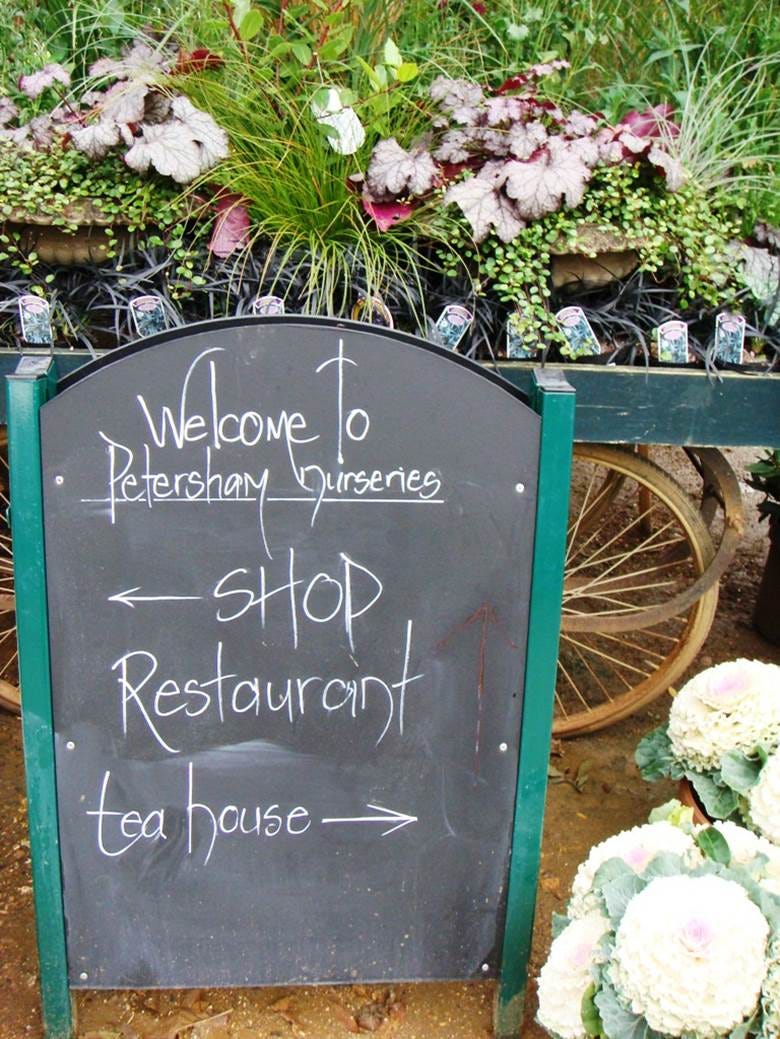 A sign with a sign in front of a flower shop

Description automatically generated
