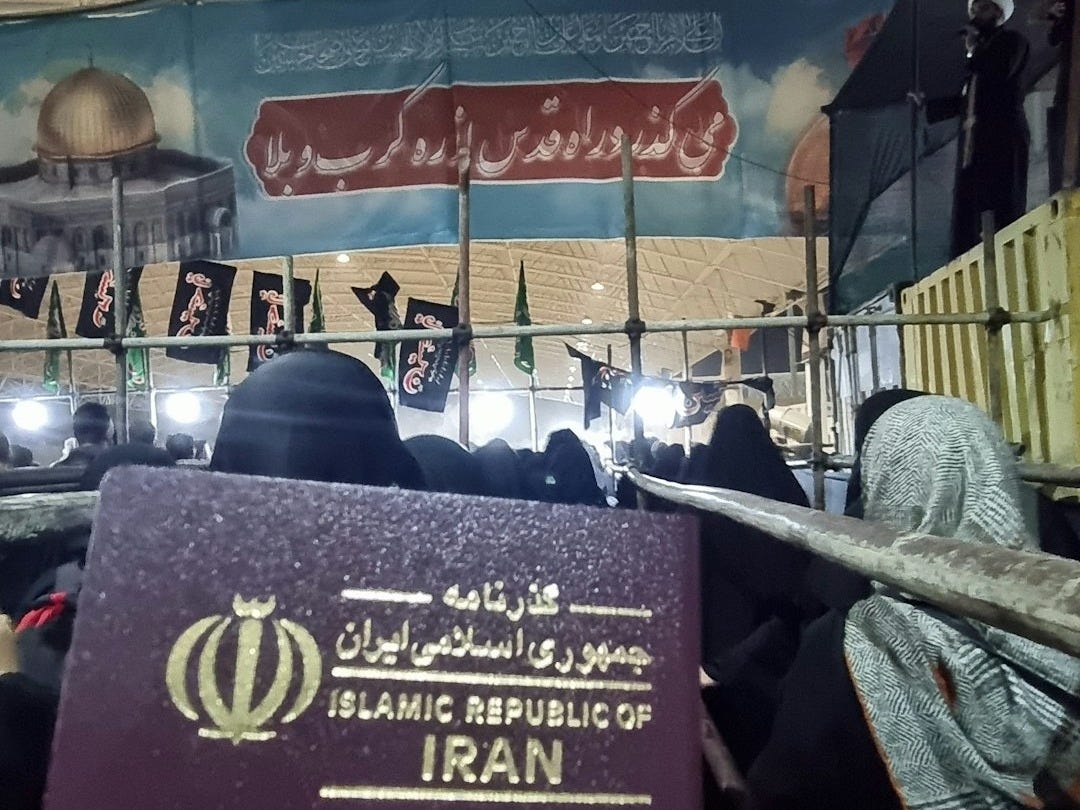 A person holding a passport in front of a crowd of people A person holding a passport in front of a crowd of people