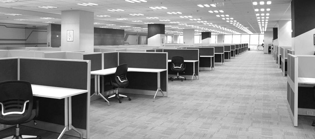an empty office cubicle with chairs and desks an empty office cubicle with chairs and desks