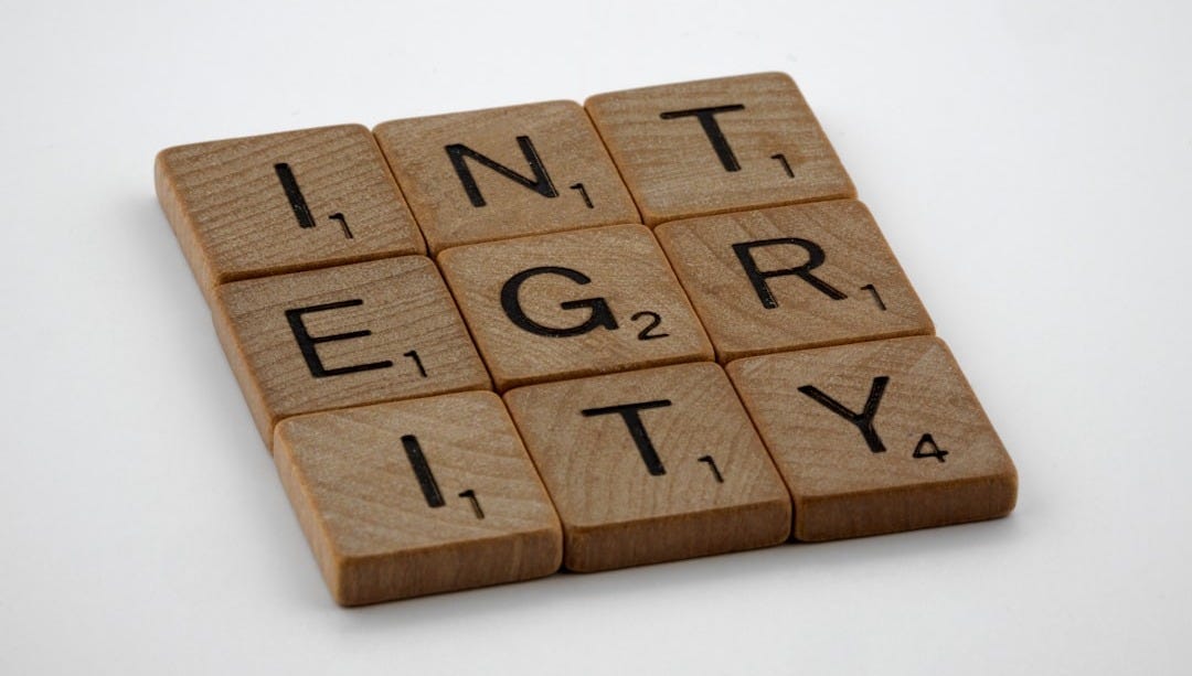 a scrabbled wooden block with the words integr city on it