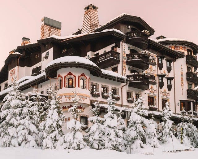Snow-covered mountain lodge surrounded by trees Snow-covered mountain lodge surrounded by trees
