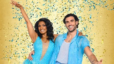 Balvinder wears a baby blue sparkling dress and Julian wears a light blue shirt, white top and blue trousers