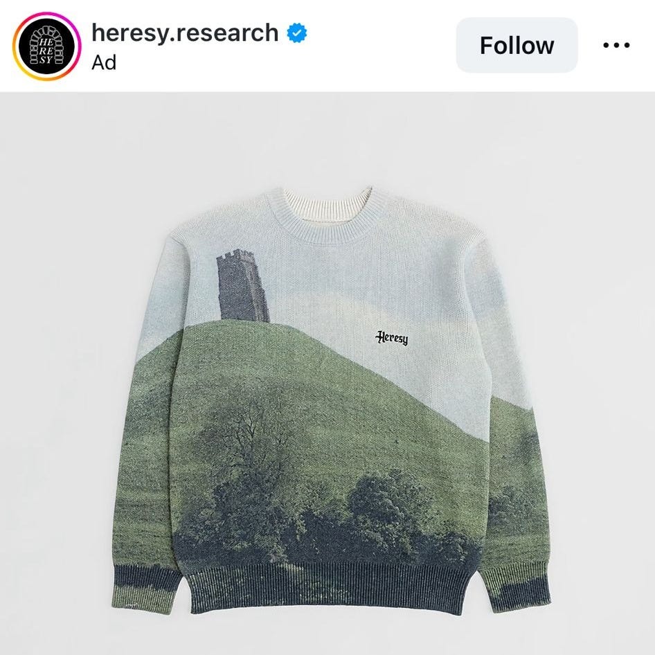 Instagram screenshot of a Heresy Research advert showing a knit sweater printed with a green hill and tower landscape, included as a visual reference in Tarot DMs with Emma van Straaten.