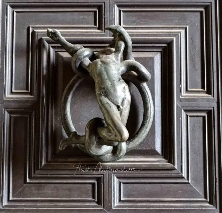 A pair of metal door knockers featuring a female and male nude figure, in sexual ecstasy, and in the embrace of a snake.