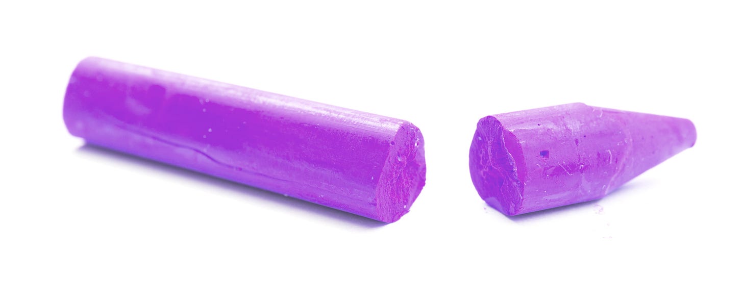 Close-up of a broken purple crayon split into two pieces on a white background.