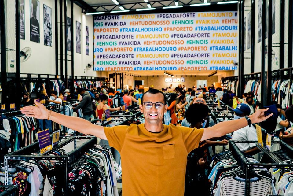 image of a man in a second hand clothers shop with open arms and wearing a yellow shirt image of a man in a second hand clothers shop with open arms and wearing a yellow shirt
