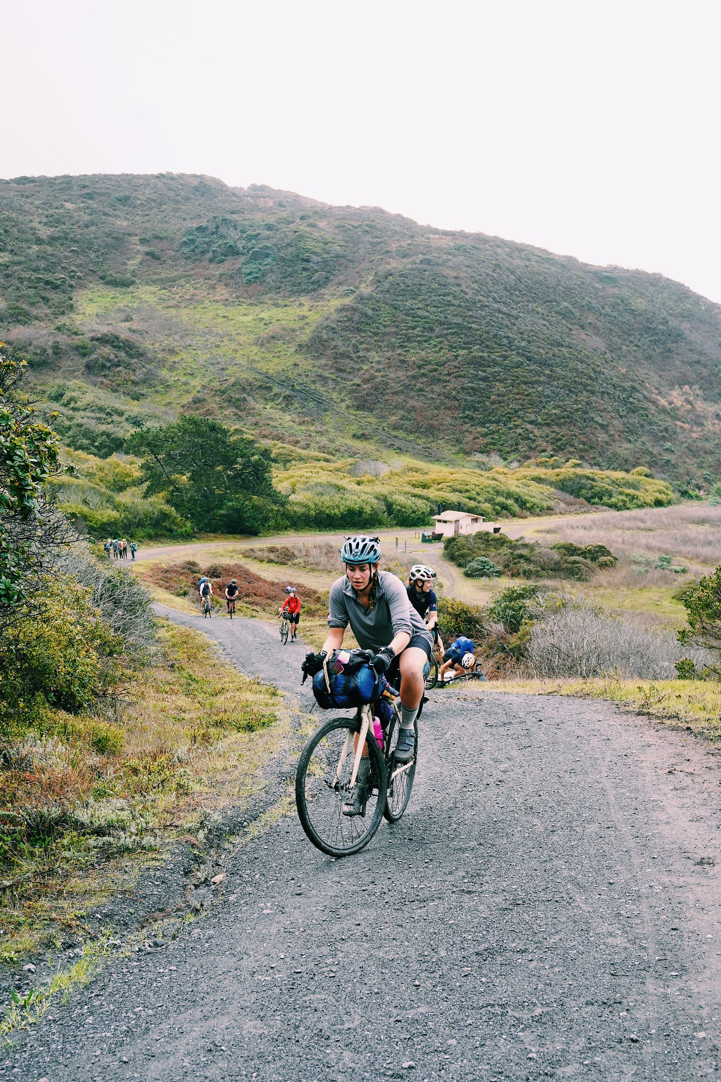 Many people slogging up a huge hill on their bikes
