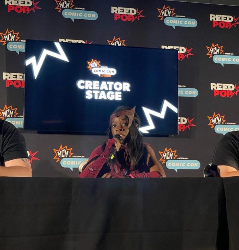 A picture of me sat on stage at comic con dressed as the Scarlett Witch