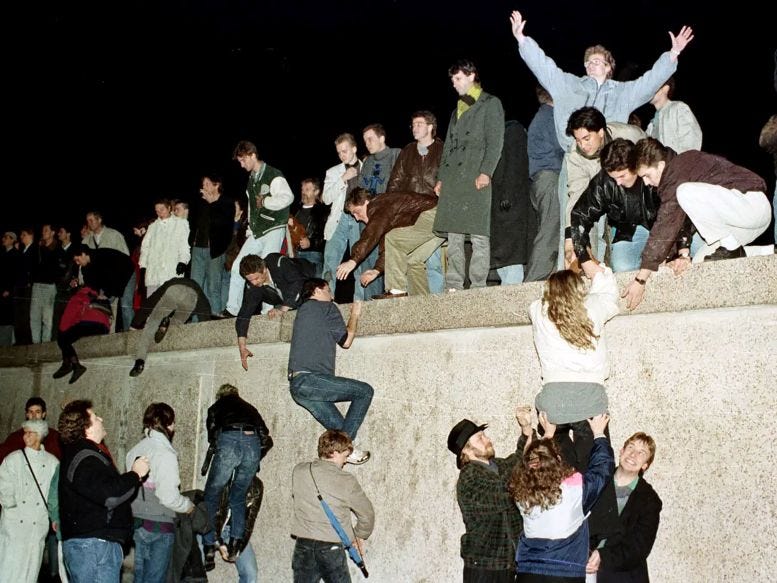 Figure 5: East Berliners climbing the Berlin Wall on November 9, 1989.