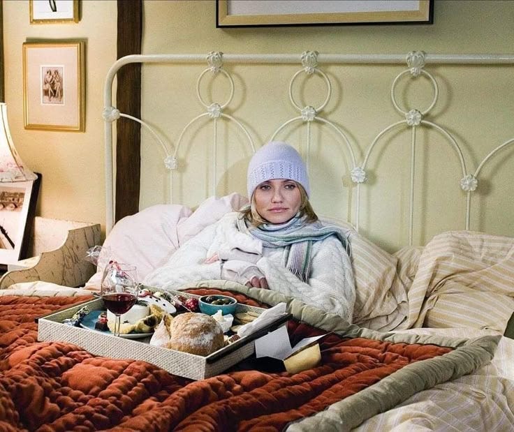 This may contain: a woman laying in bed with an open suitcase