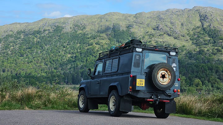 Land Rover Defender, camp chair and an English Setter dog.