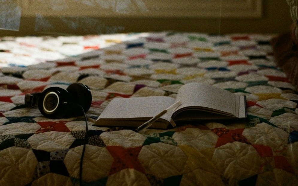 A camera sitting on top of a bed next to a window