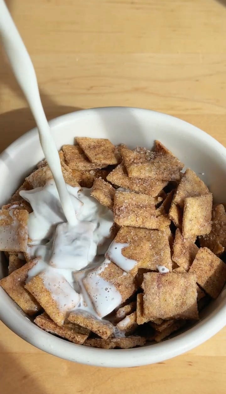 Jars of cereal and a bowl of cinnamon toast crunch with milk.