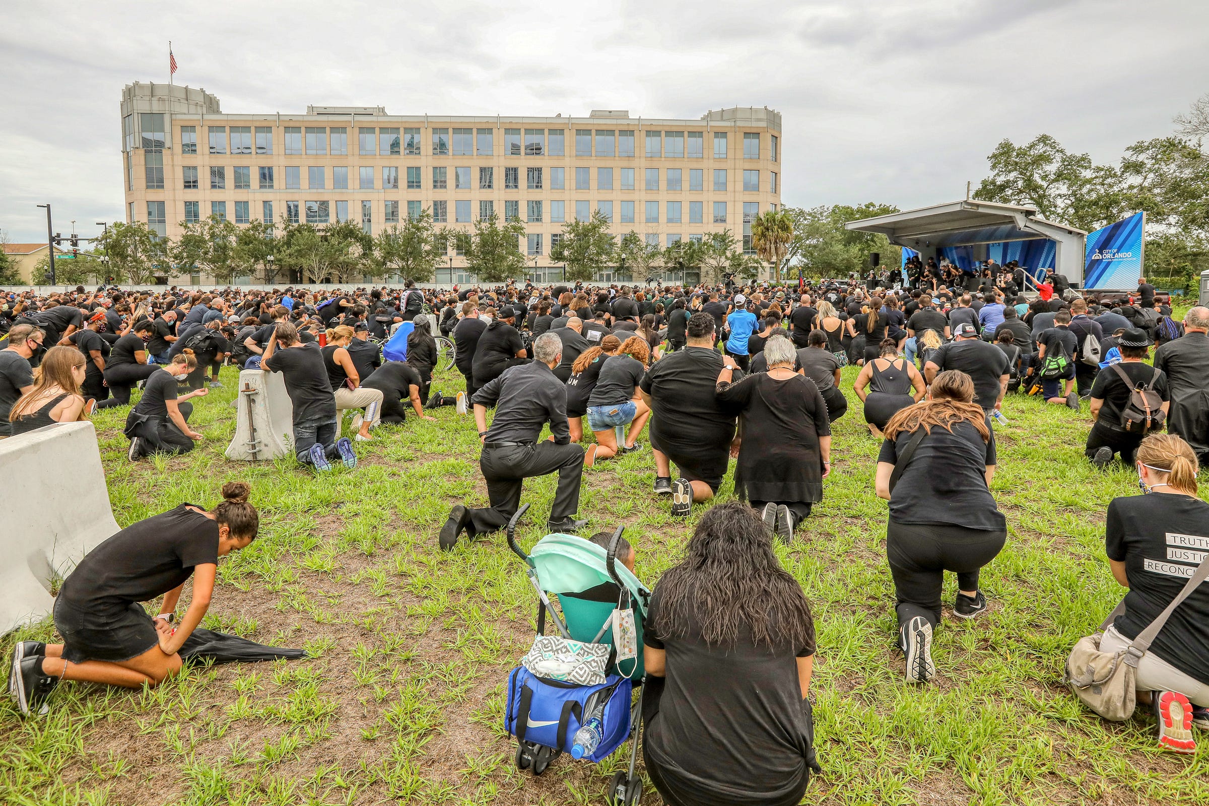 Multitude kneeling in prayer on grass in the open Multitude kneeling in prayer on grass in the open