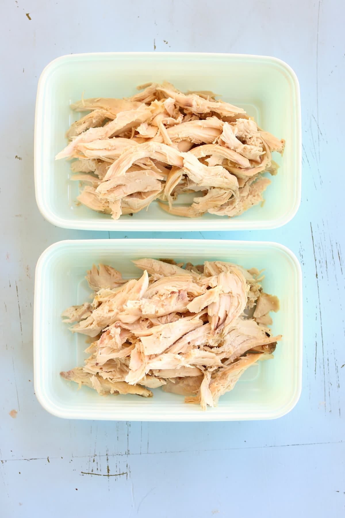 two meal prep containers of shredded chicken. two meal prep containers of shredded chicken.