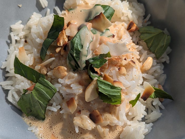 Finished bowl of creamy coconut rice with peanut drizzle. First bite of the bowl.