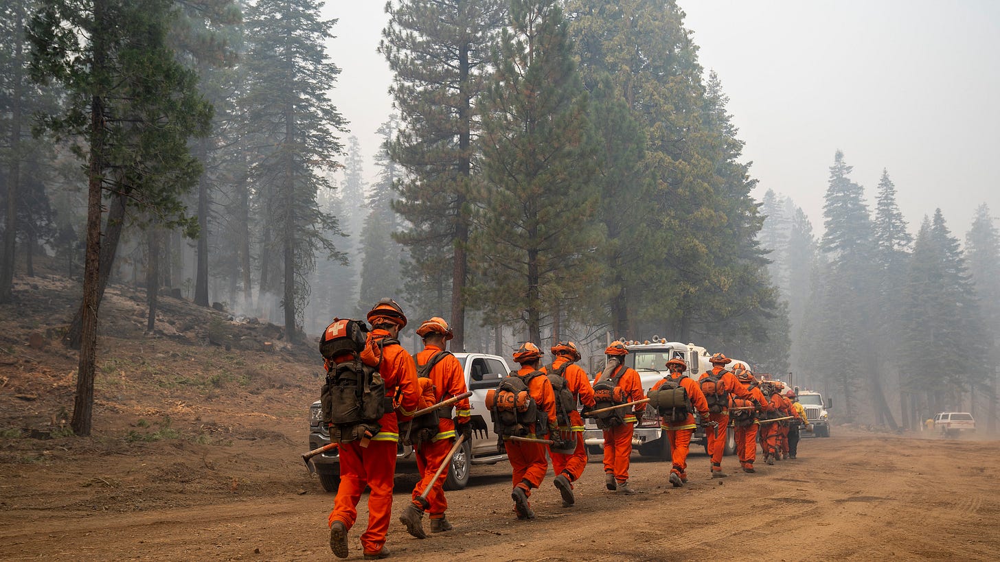 Inmate firefighters with CAL Fire march to the fire line to help suppress the Dixie Fire