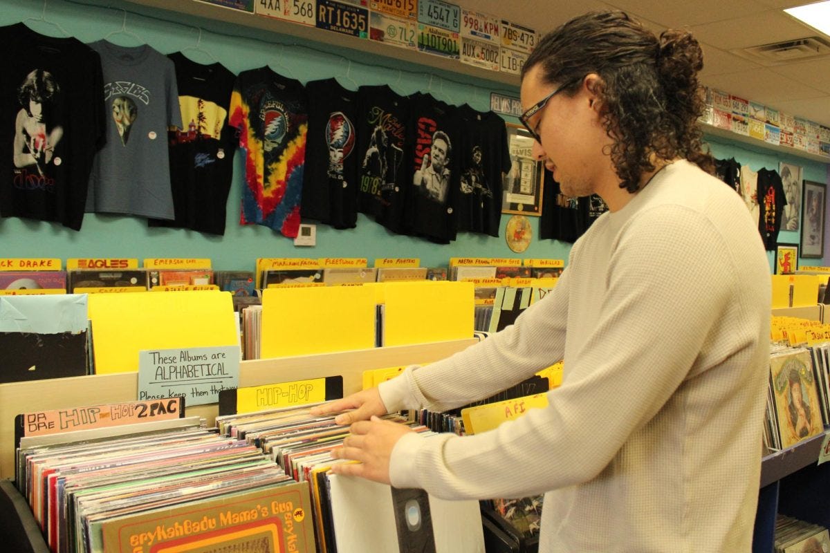 Dudley's Records Vintage Vinyl store employee and El Camino College music major Seth Landoch, 23, flips through the store's inventory of vinyl records Friday, April 25. Landoch is in his third semester at ECC. (Elsa Rosales | The Union)