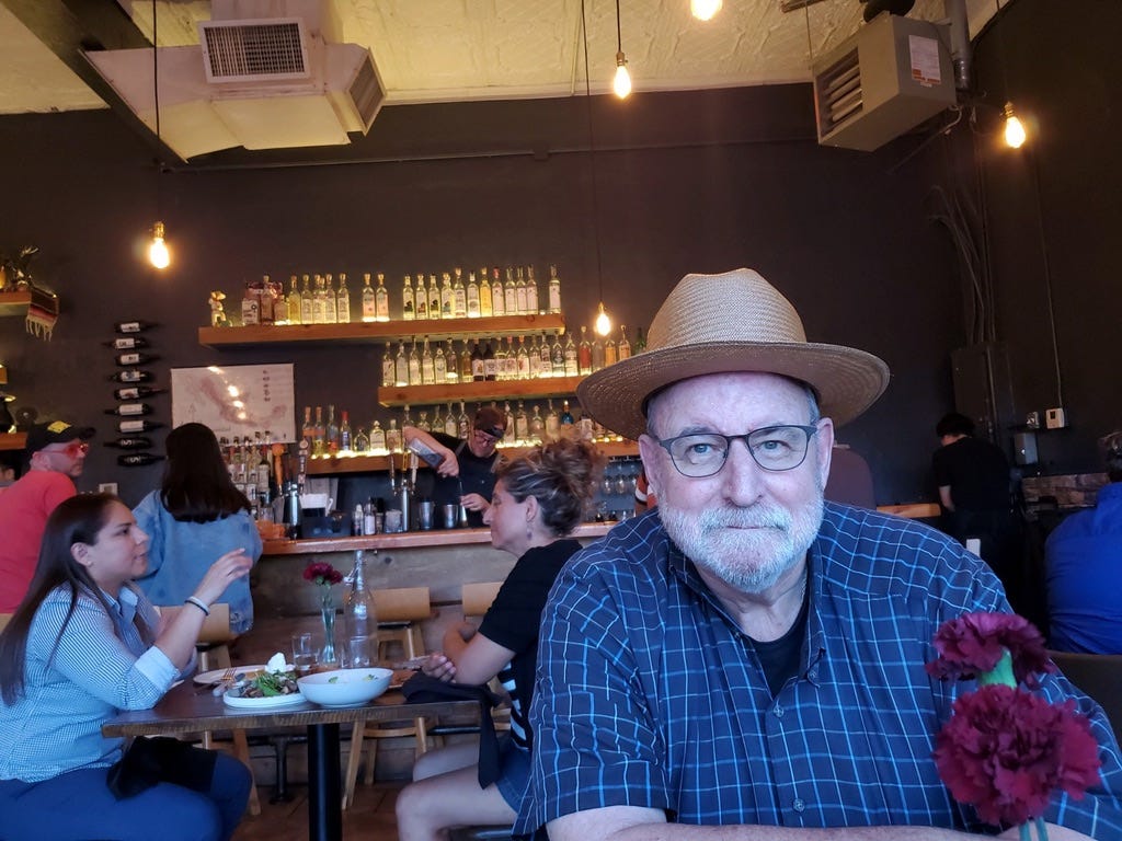 A person sitting at a table with a hat

Description automatically generated