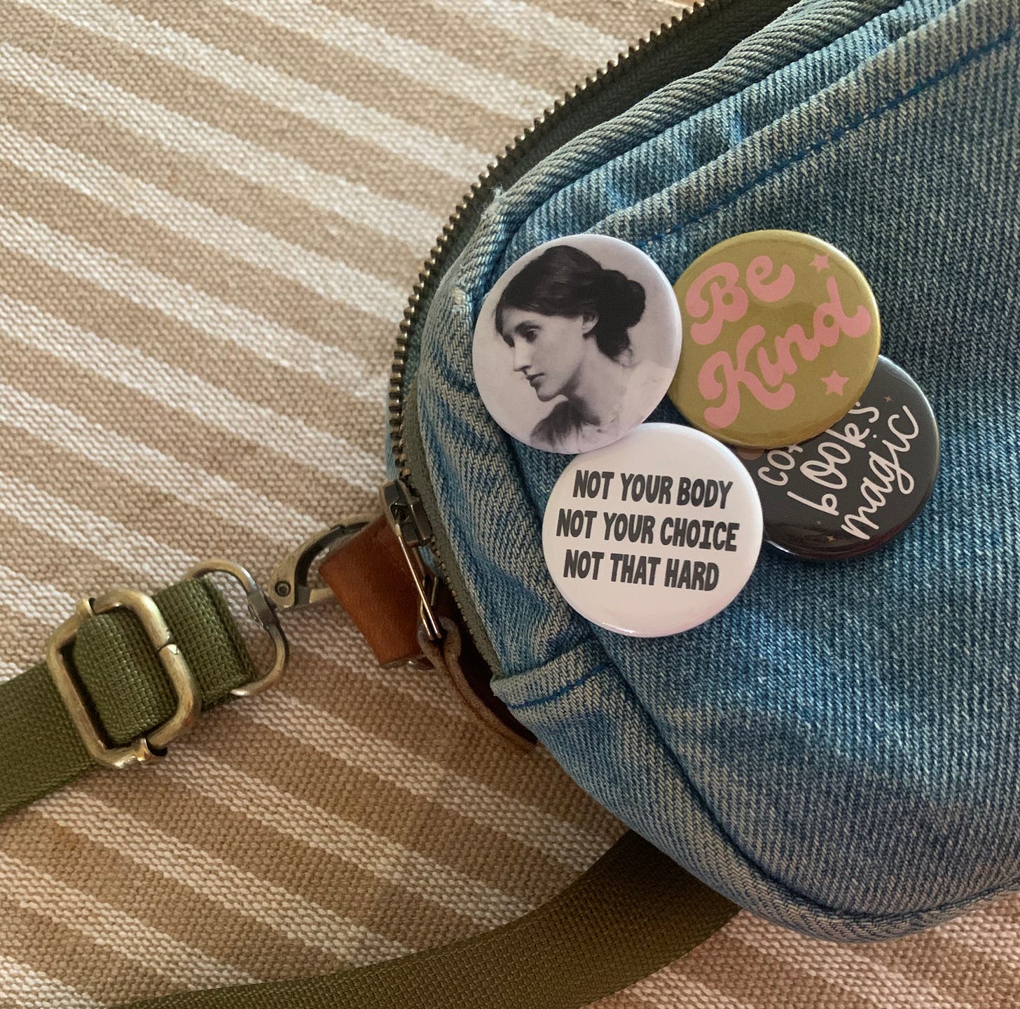 part of my denim belt bad with 4 pins on it: Virginia Woolf, "Be Kind", "Coffee Books Magic" and a pro choice one