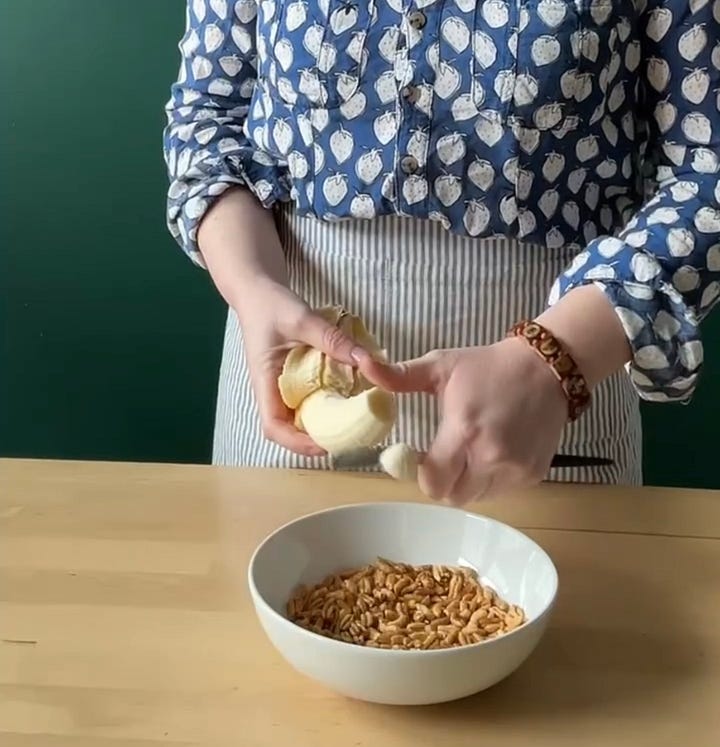 Woman making homemade cereal and slicing a banana into it.