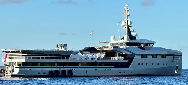 A large, squat vessel with a helipad at the back.