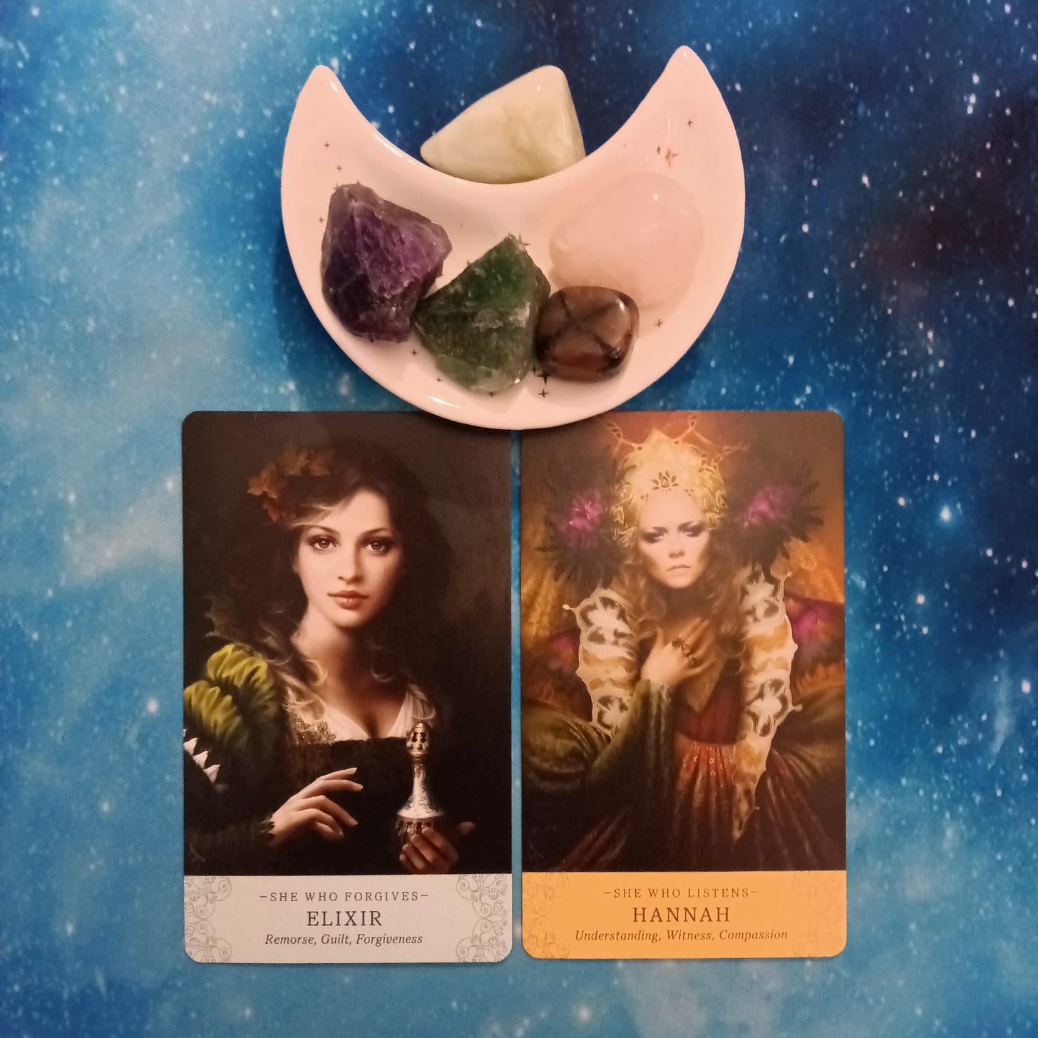 2 Elle Qui Oracle cards and crystals on a starry blue background 2 Elle Qui Oracle cards and crystals on a starry blue background