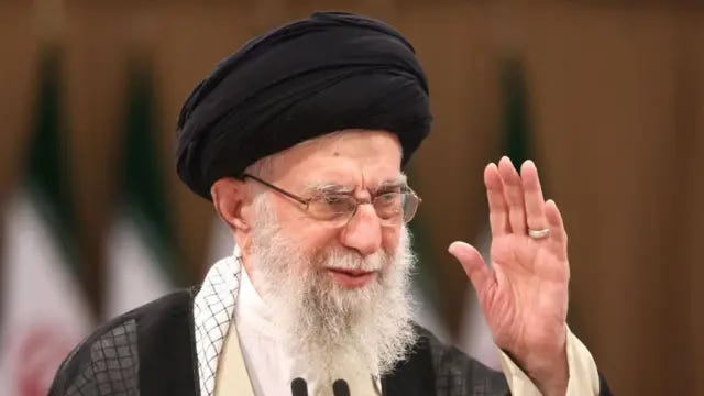 Iran's Supreme Leader Ayatollah Ali Khamenei with one hand raised