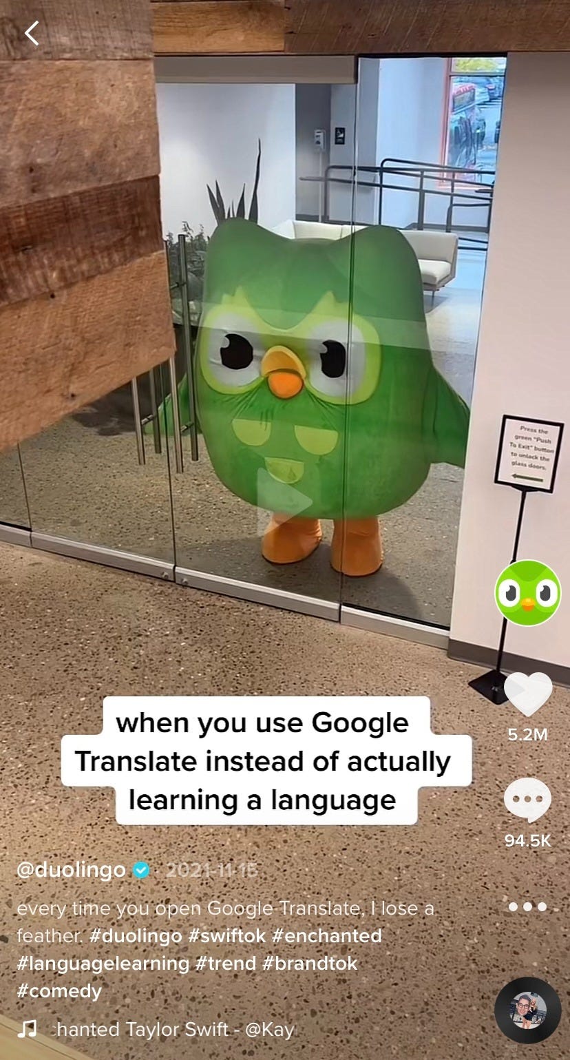 A 2021 TikTok post from Duolingo featuring their famous green owl mascot staring through clear conference room doors