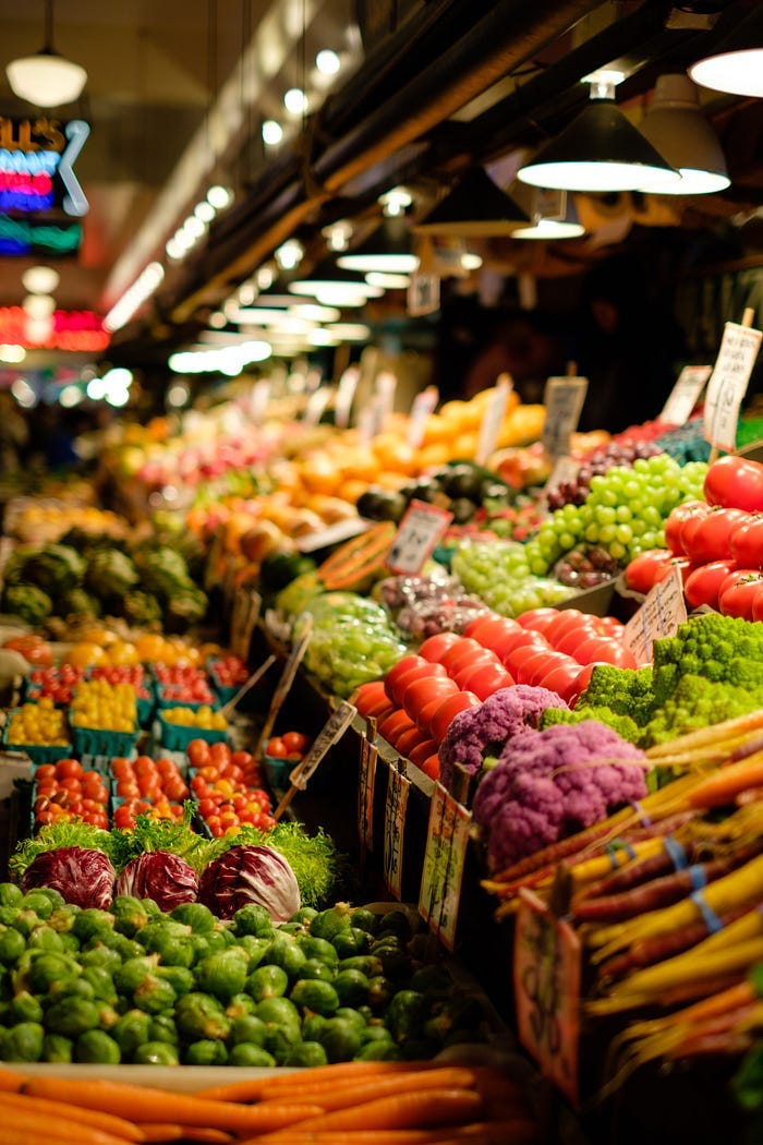 A grocery store full of brightly colored fruit and vegetables.