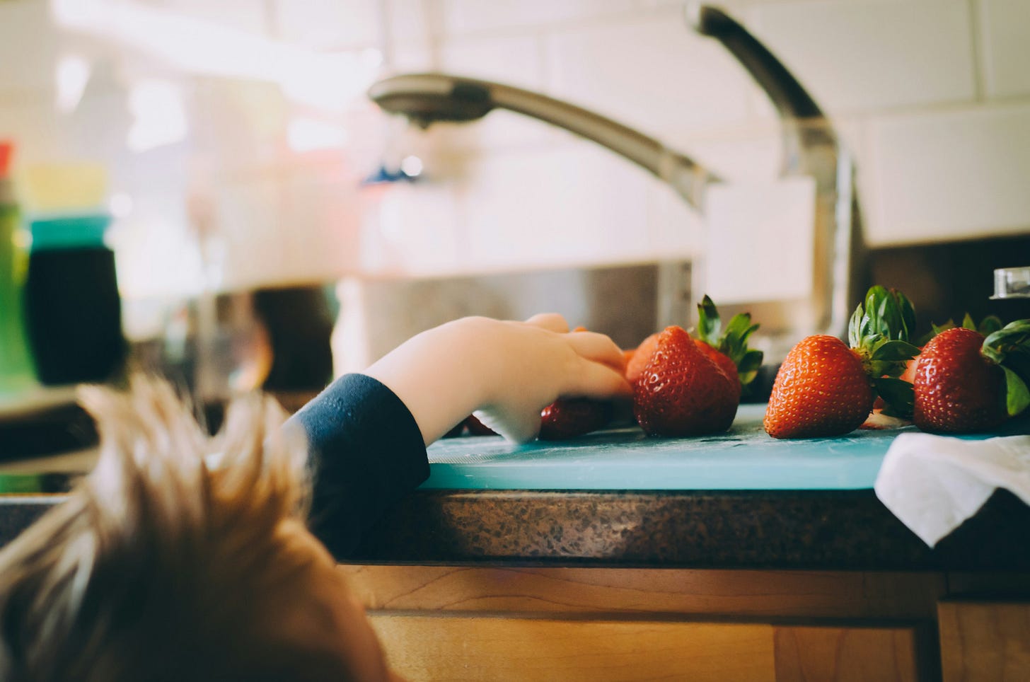 child picking strawberries in kitchen child picking strawberries in kitchen