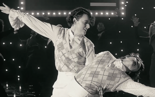 A gif of the final shot of the Treat People With Kindness video. Phoebe Waller-Bridge is dipping Harry in a final showstopping move. Her arm is outstretched and she glances to the camera with a knowing smirk.