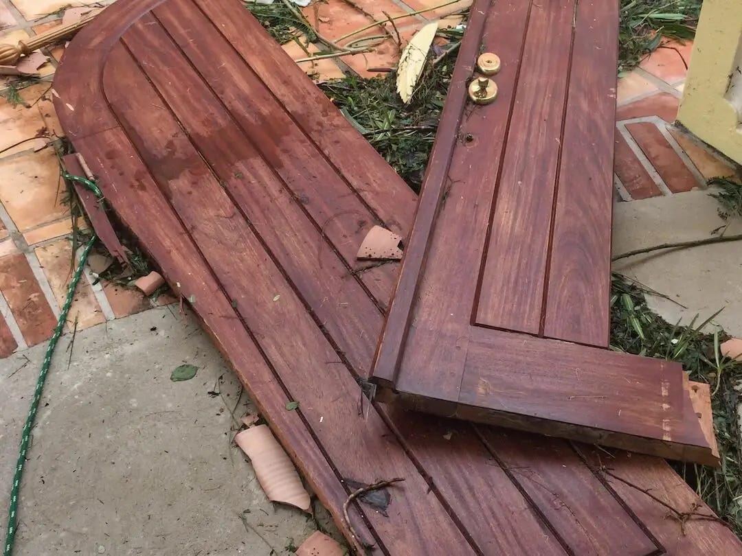 Brown wooden doors laying smashed on the ground