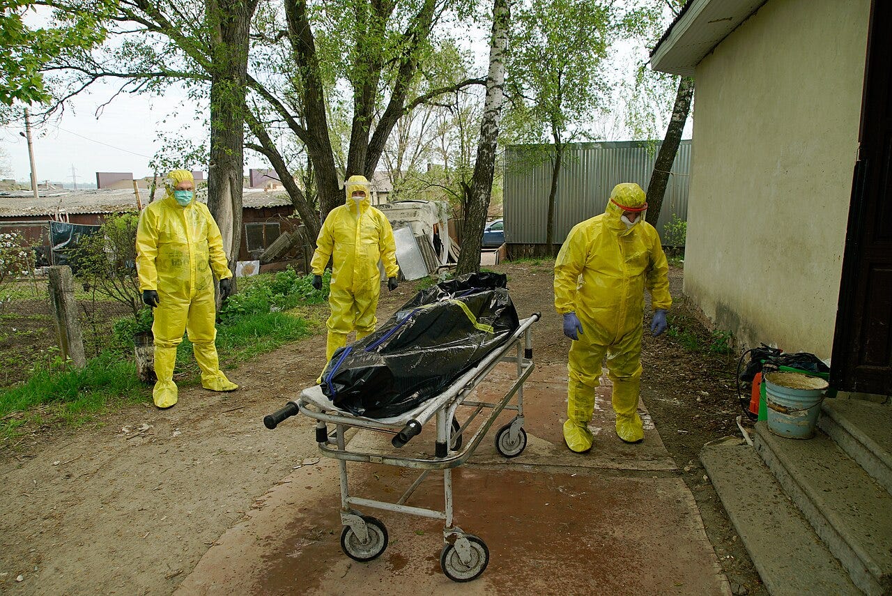 Photo: Mstyslav Chernov / Wikimedia Commons (CC BY-SA 4.0) Autopsy performed outdoors by medical examiners wearing special protective suits. Krinytsa, Ternopil oblast, Ukraine.