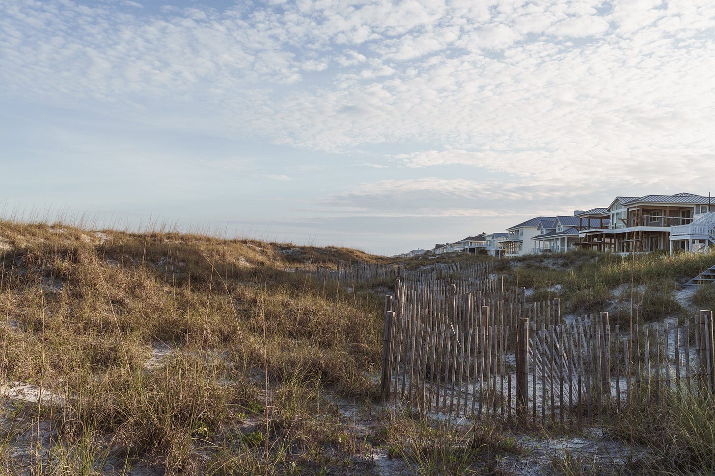sand dunes and beach fences in front of beach houses on figure eight island, north carolina