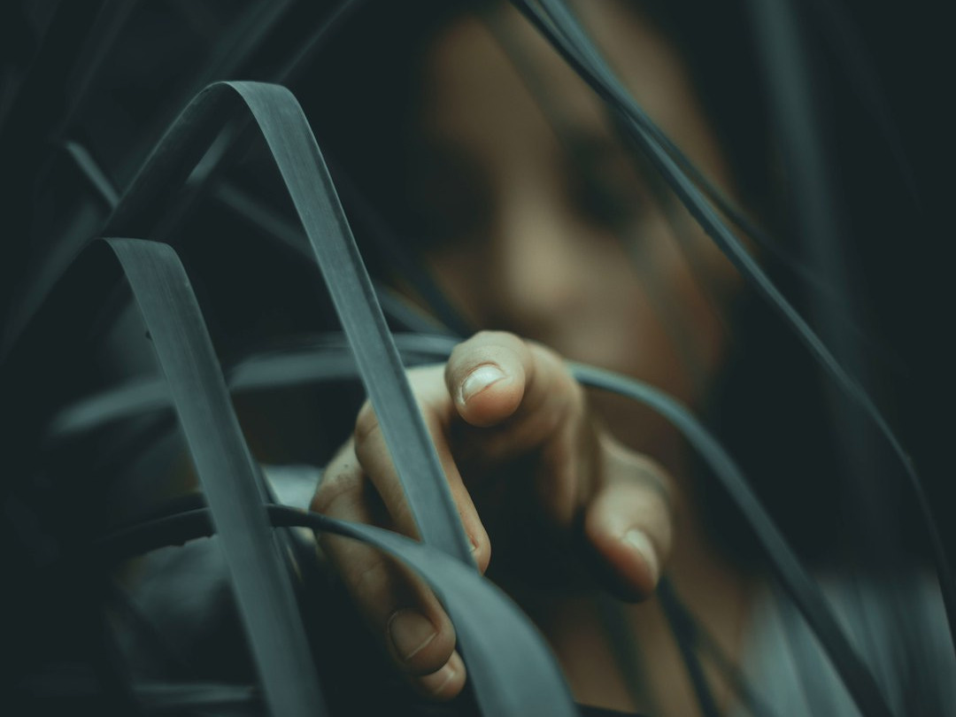woman in gray shirt behind plant woman in gray shirt behind plant