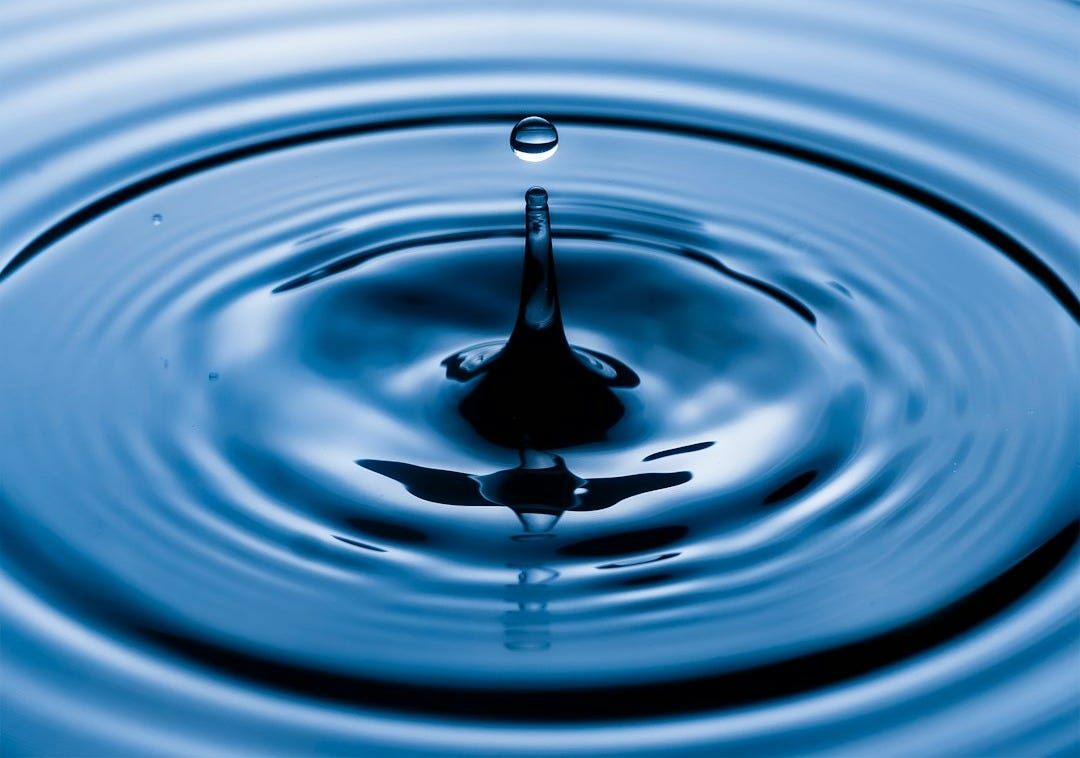 water drop in water in grayscale photography