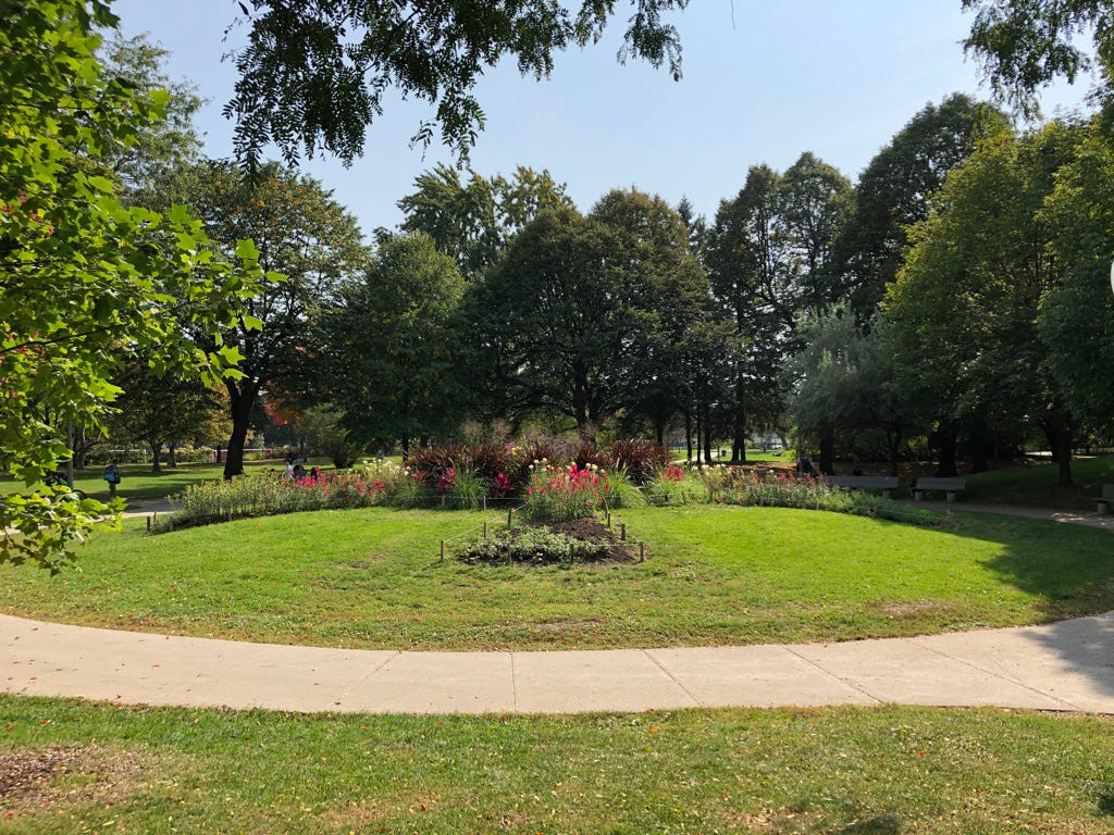 A circular lawn with flowers and trees in the background

AI-generated content may be incorrect.