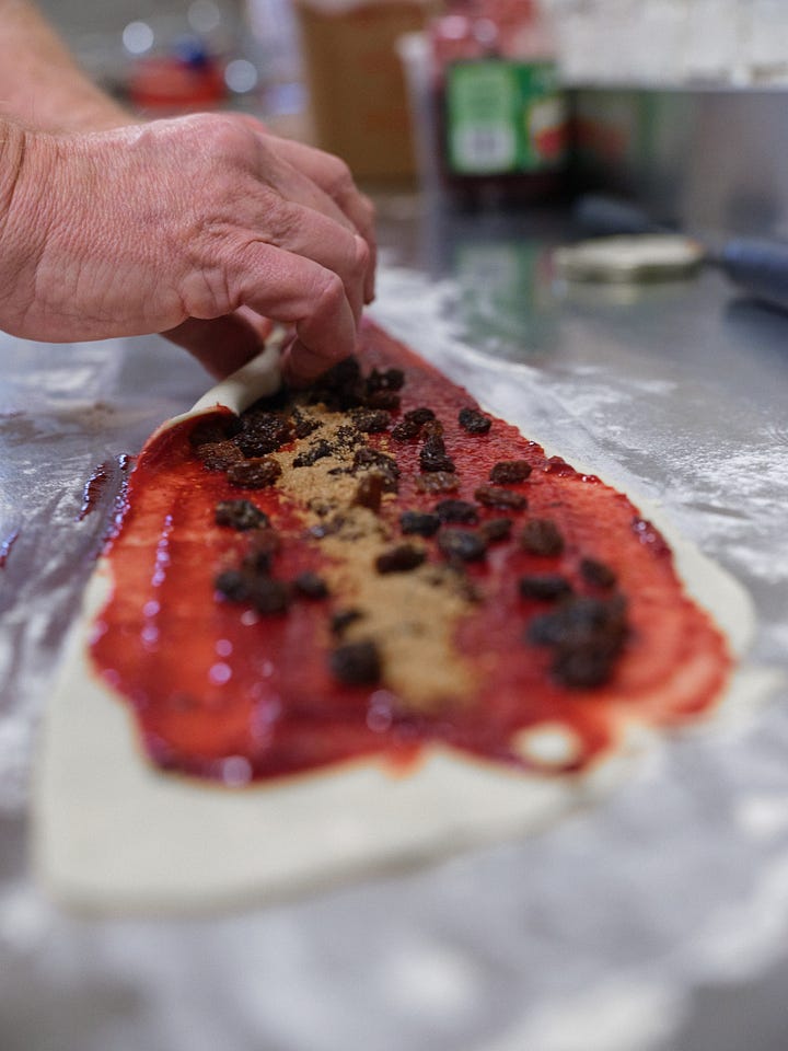 Sprinkling the raising, rolling the the filled dough into a spiraled log