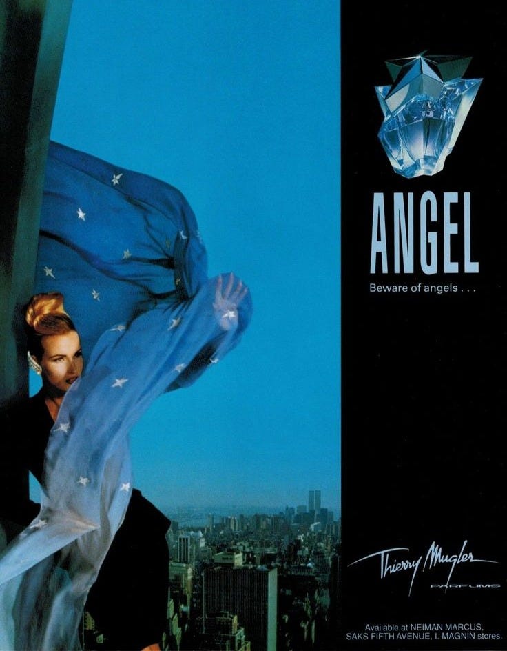 This may contain: an advertisement for angel perfume with a woman in the background holding a blue scarf over her head This may contain: an advertisement for angel perfume with a woman in the background holding a blue scarf over her head