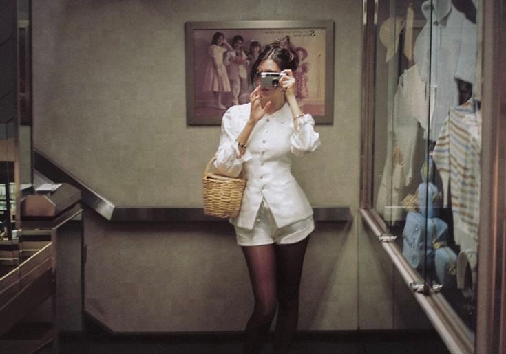This may contain: a woman taking a selfie in front of a mirror