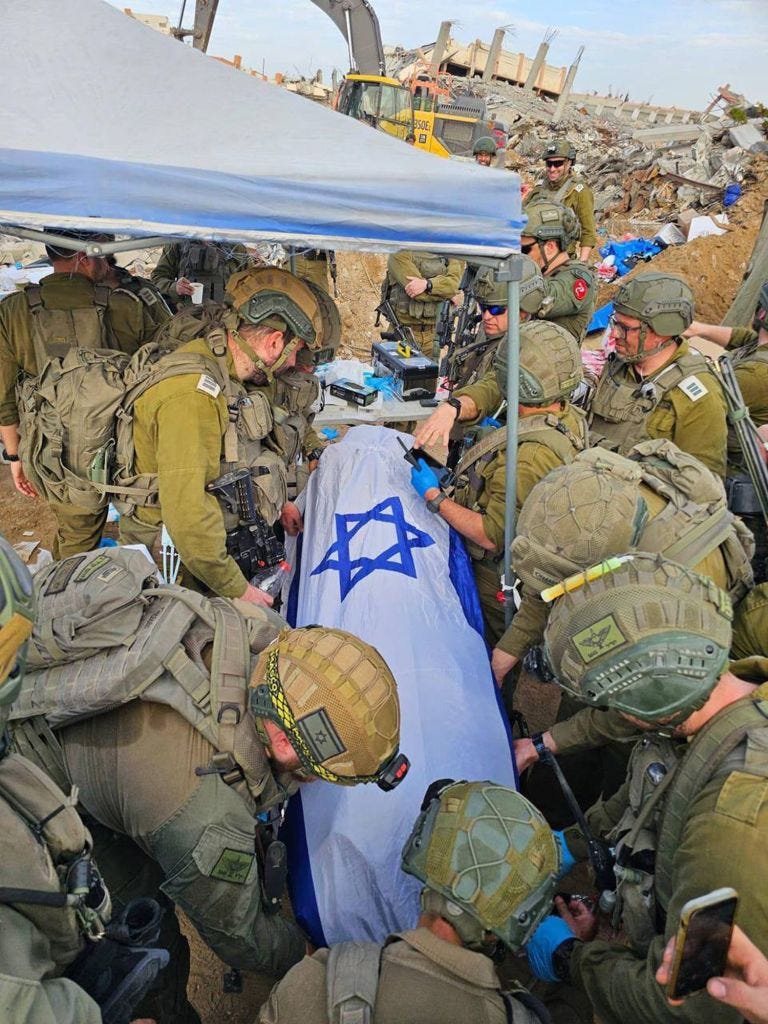 Israeli soldiers gather around a flag-draped body found in the Gaza Strip.