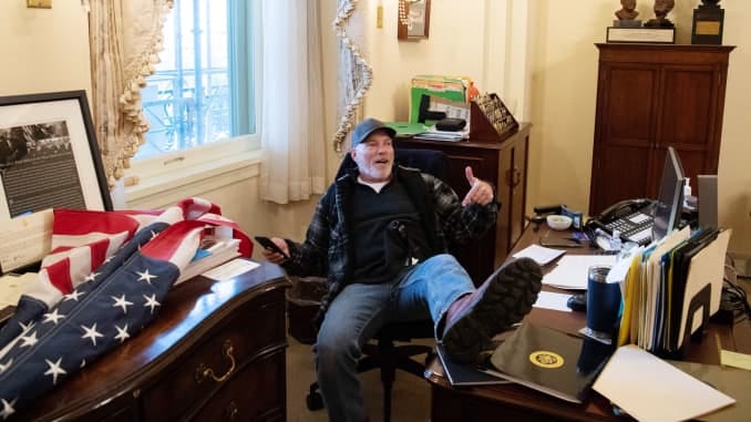A supporter of US President Donald Trump sits inside the office of US Speaker of the House Nancy Pelosi as he protest inside the US Capitol in Washington, DC, January 6, 2021.