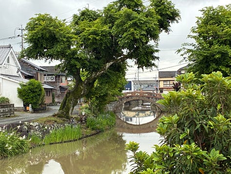 Photos of a pink and grey stone arch bridge over a dull green-brown waterway, overhung with trees