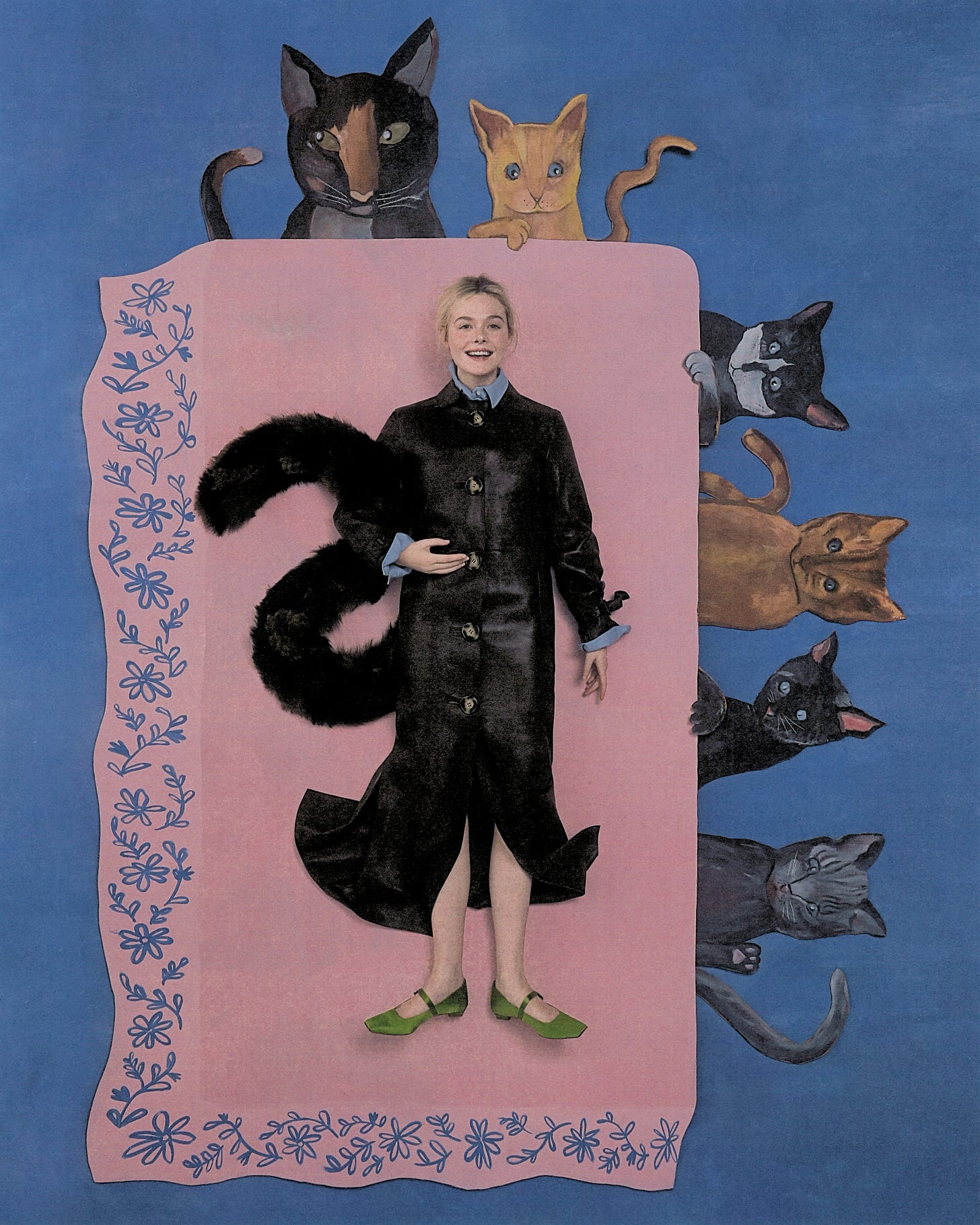 Elle Fanning shot by Szilveszter Mak&amp;amp;oacute;. She is lying flat on a table made of painted cardboard. The tablecloth is pink with painted flowers on the border. Sitting around the table are cutout cats made of painted cardboard. Fanning is wearing a long, buttoned leather coat with green Mary Jane flats. She is holding a faux fur scarf styled like a cat tail.